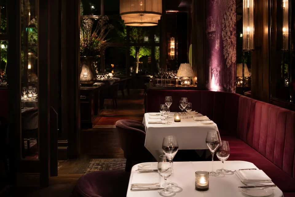 An elegant dining room with banquettes and warm lighting