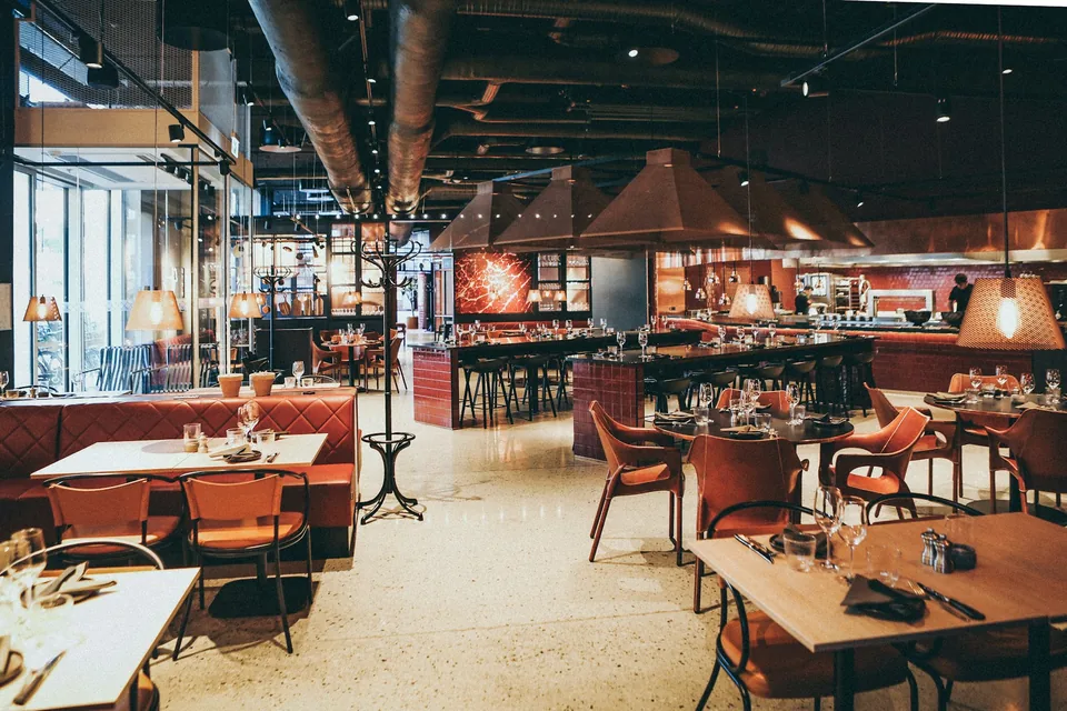 Warm restaurant interior with booths and pendant lights